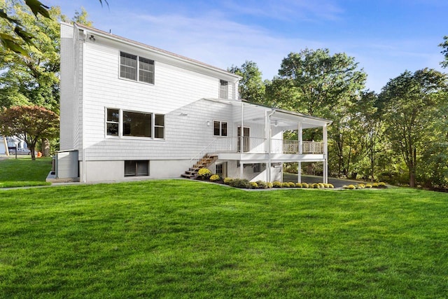 rear view of house with a lawn and a sunroom