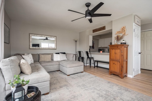 living room featuring ceiling fan and light wood-type flooring