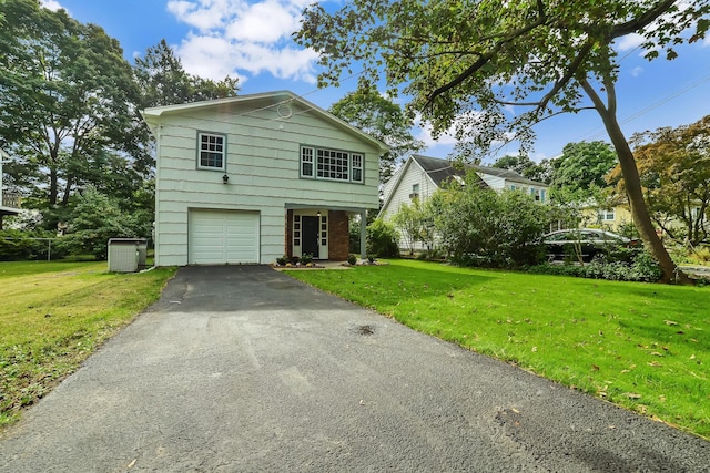 view of front of house with a front yard, central AC unit, and a garage