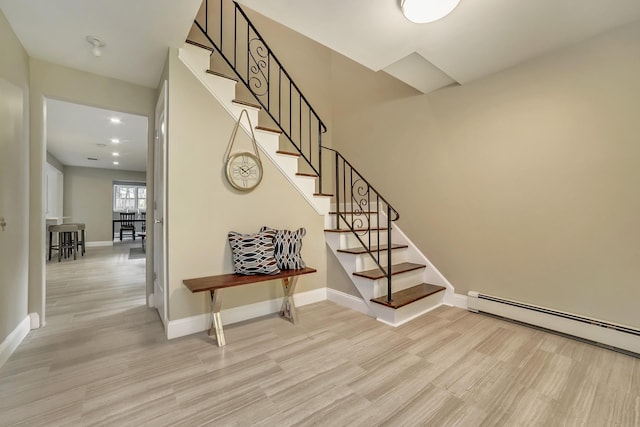 stairs featuring a baseboard radiator and hardwood / wood-style flooring