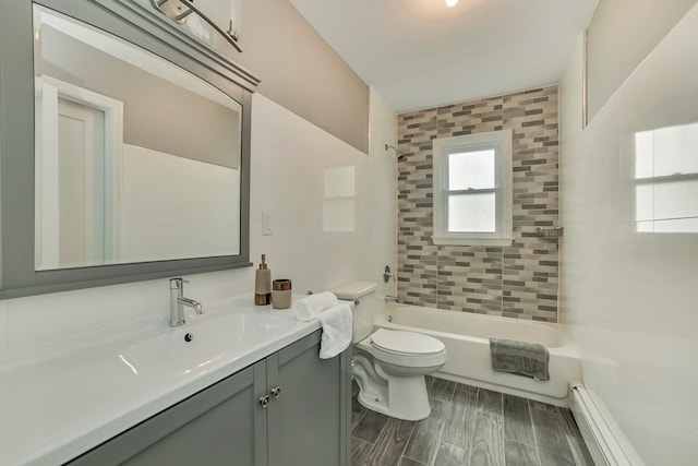 full bathroom featuring toilet, tiled shower / bath combo, vanity, and a baseboard radiator