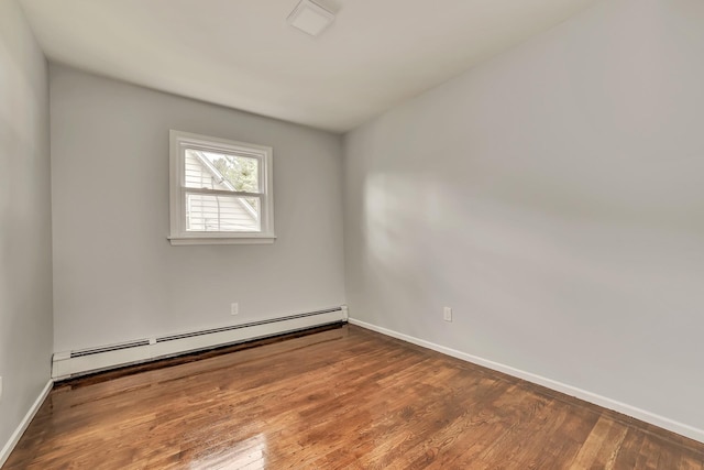 spare room with a baseboard heating unit and wood-type flooring