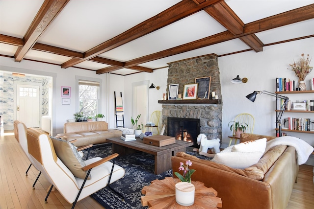 living area featuring wood-type flooring, coffered ceiling, and a stone fireplace