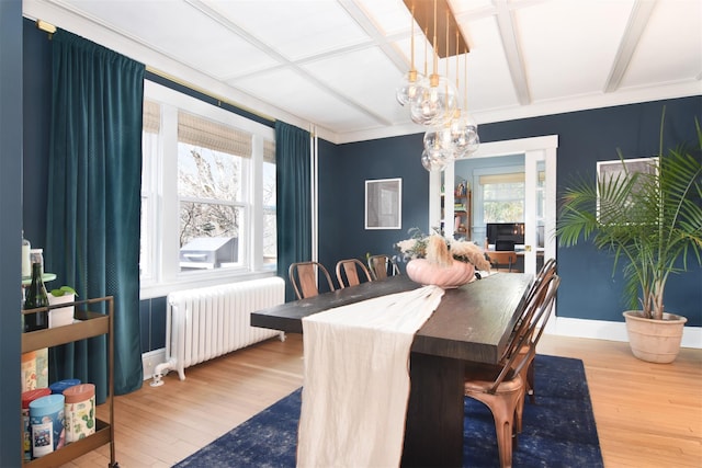 dining space featuring coffered ceiling, radiator, wood finished floors, a chandelier, and beam ceiling