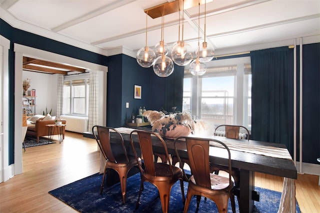 dining space with radiator, beam ceiling, and light wood finished floors