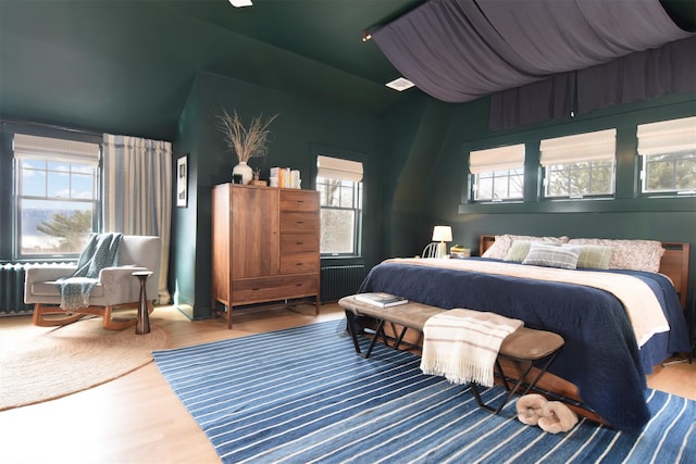 bedroom with vaulted ceiling and wood finished floors