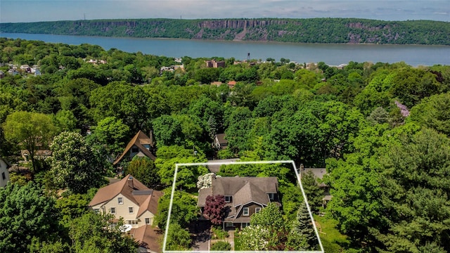 aerial view with a water view and a wooded view