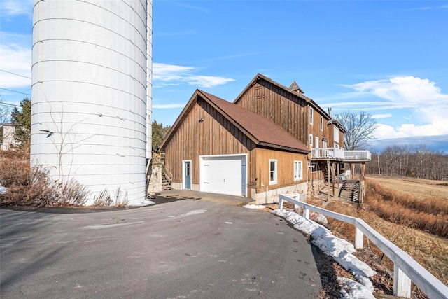 view of property exterior with a wooden deck and a garage