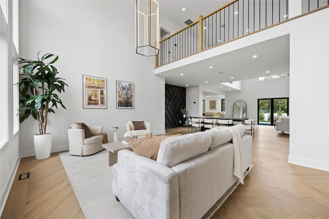 living room with a high ceiling and light parquet flooring