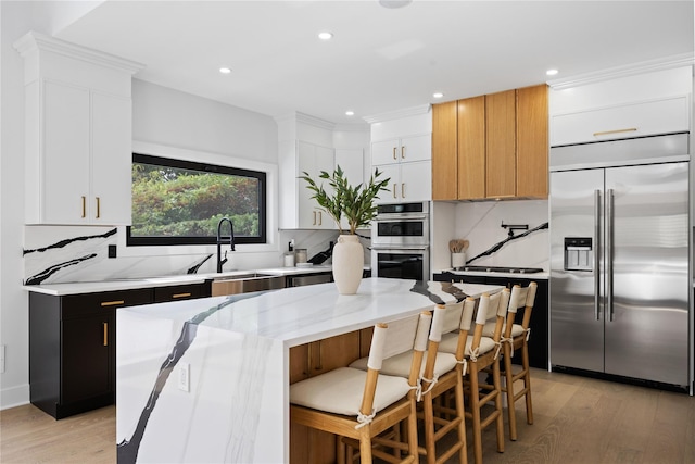 kitchen featuring sink, stainless steel appliances, a center island, and white cabinets