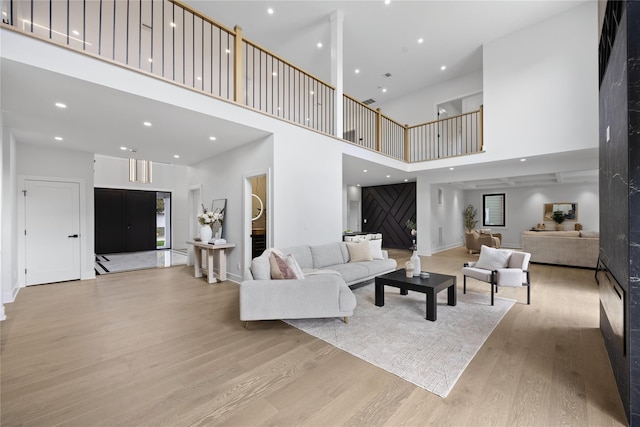 living room with a towering ceiling and light hardwood / wood-style flooring