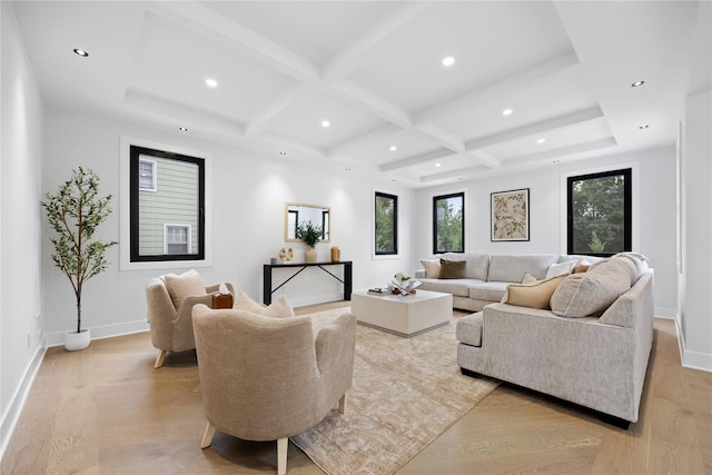 living room with coffered ceiling, beamed ceiling, light hardwood / wood-style flooring, and a healthy amount of sunlight