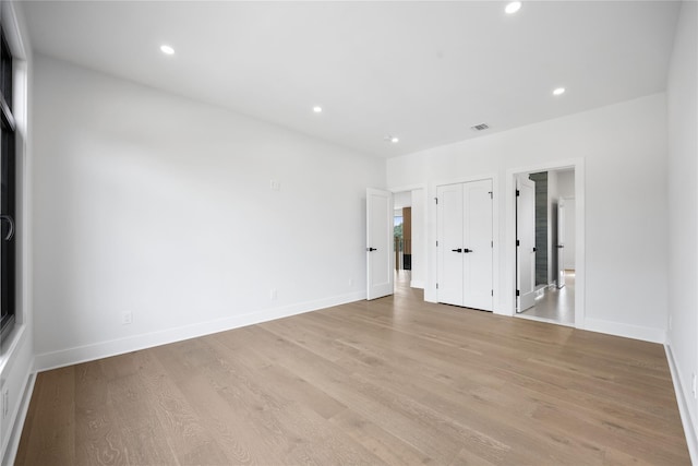 unfurnished bedroom featuring light hardwood / wood-style floors and connected bathroom