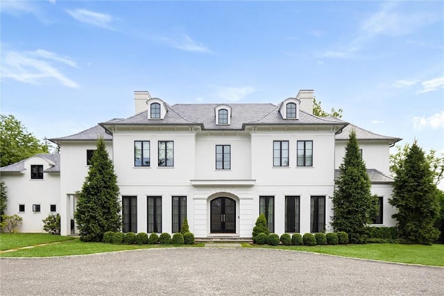 french country inspired facade with a front yard