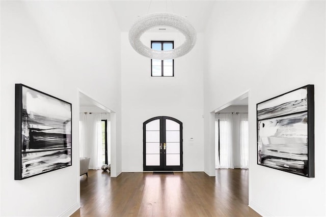 entrance foyer featuring a high ceiling, dark hardwood / wood-style flooring, and french doors