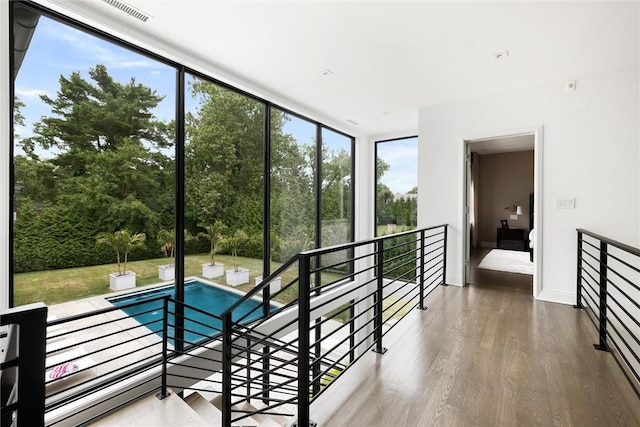 interior space with a wall of windows, hardwood / wood-style flooring, and plenty of natural light