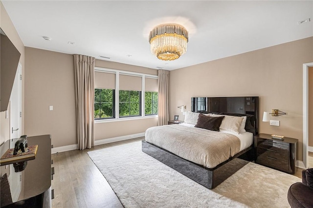 bedroom with a notable chandelier and wood-type flooring