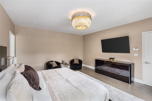 bedroom featuring light hardwood / wood-style floors and an inviting chandelier