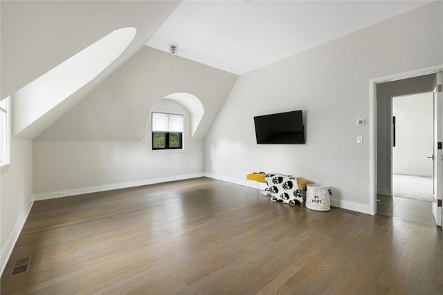 bonus room with dark wood-type flooring and vaulted ceiling