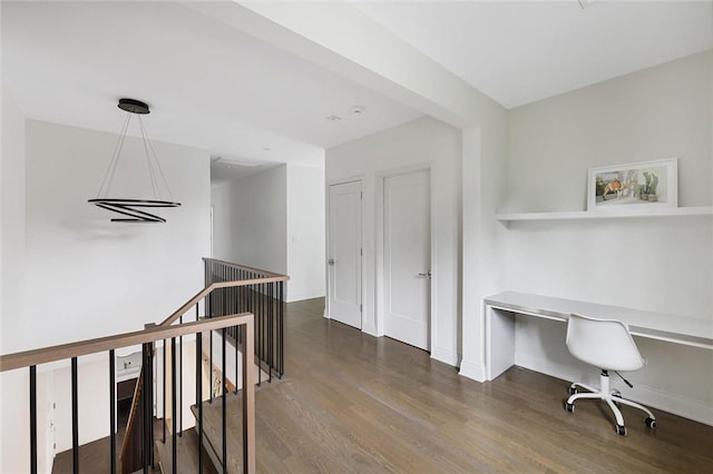 office area with built in desk and dark wood-type flooring