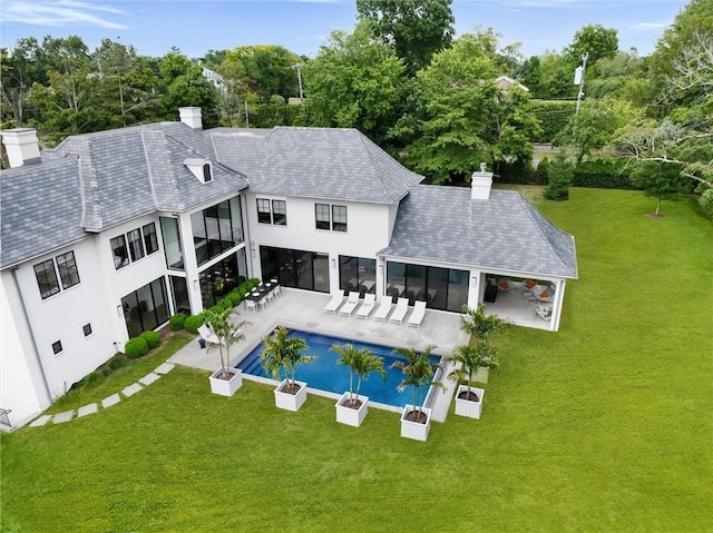 view of swimming pool featuring a patio, a sunroom, and a lawn