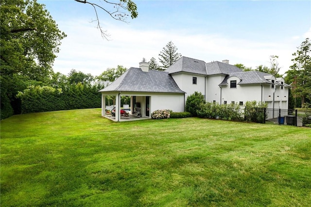 back of property featuring a yard and a patio