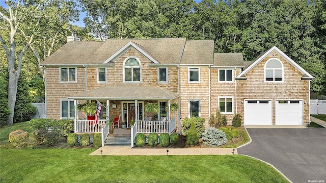 view of front of property with a front lawn, a garage, and a porch