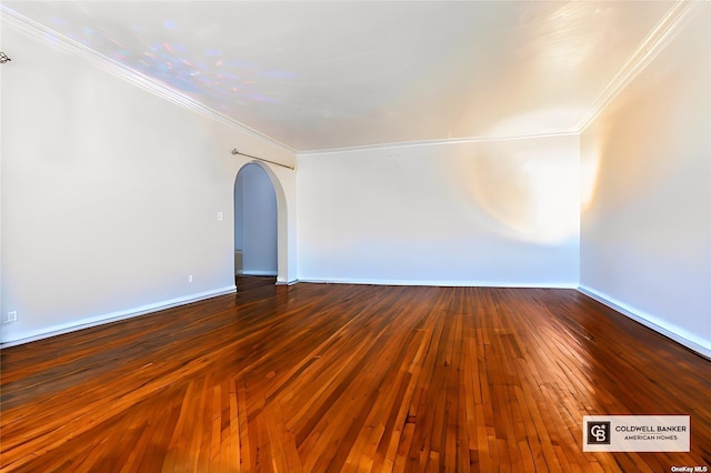 spare room featuring crown molding and dark hardwood / wood-style floors