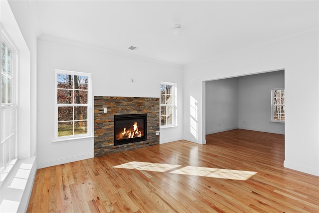 unfurnished living room with light wood-type flooring, crown molding, and a fireplace