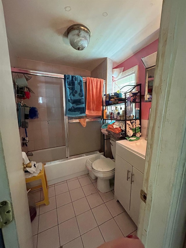 full bathroom featuring toilet, vanity, tile patterned floors, and shower / bath combination with glass door