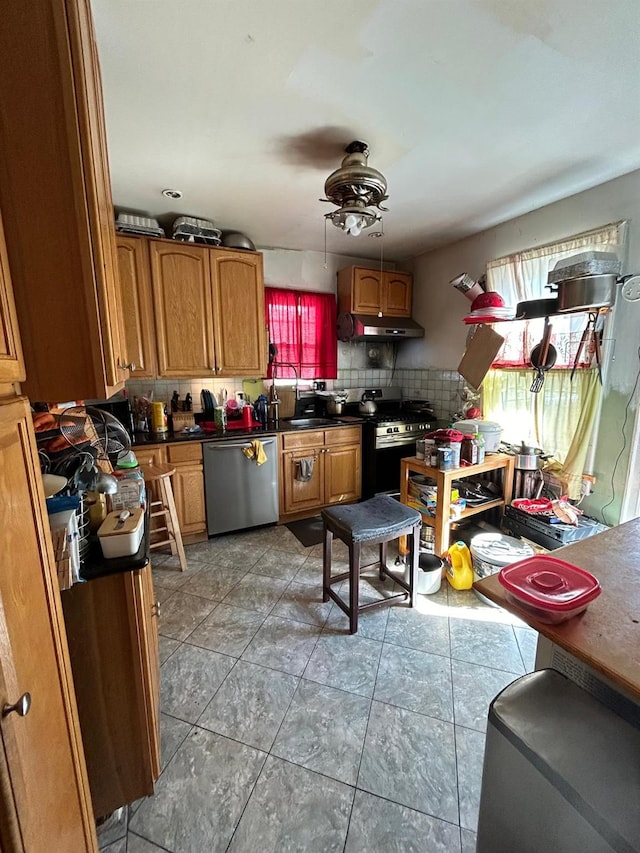 kitchen featuring stainless steel appliances, decorative backsplash, and ceiling fan