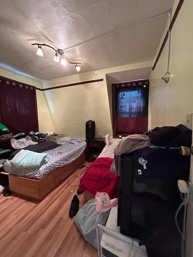 bedroom featuring a textured ceiling and hardwood / wood-style floors