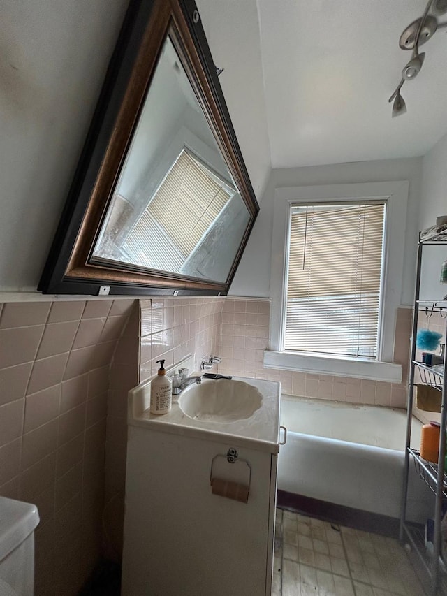 bathroom featuring toilet, vanity, decorative backsplash, and a bath