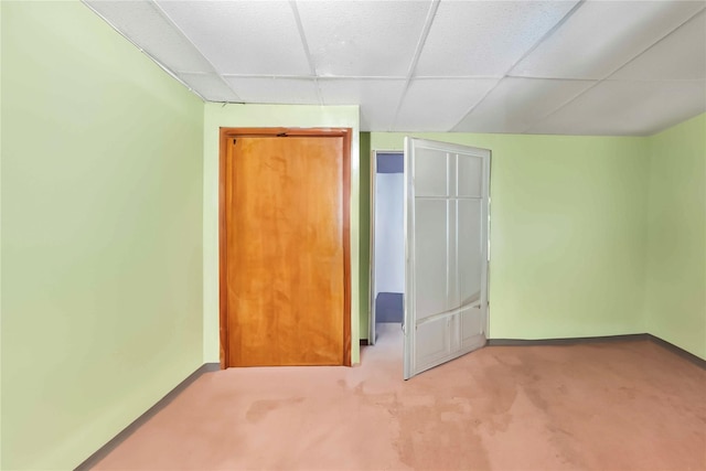 unfurnished bedroom featuring a paneled ceiling, a closet, and carpet floors