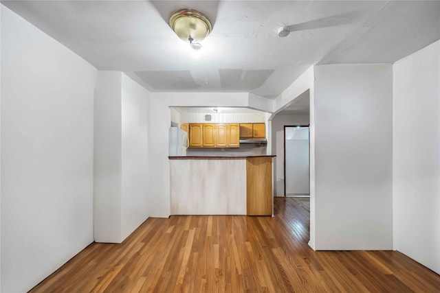 kitchen with white refrigerator and light hardwood / wood-style flooring