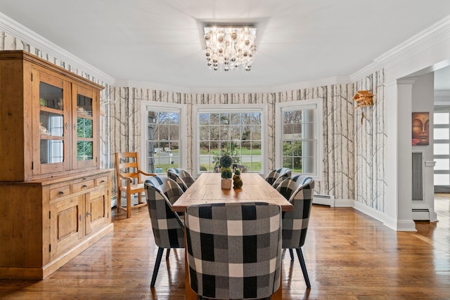 dining room featuring a baseboard heating unit, a notable chandelier, and ornamental molding