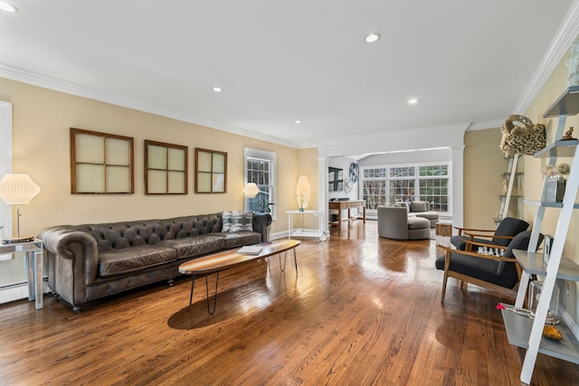 living room featuring hardwood / wood-style flooring, crown molding, and ornate columns