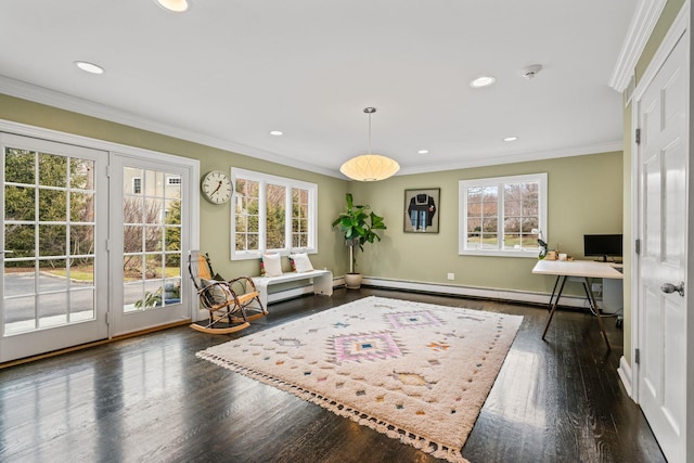 sitting room with dark wood-type flooring, baseboard heating, and crown molding