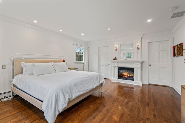 bedroom with crown molding and dark hardwood / wood-style floors