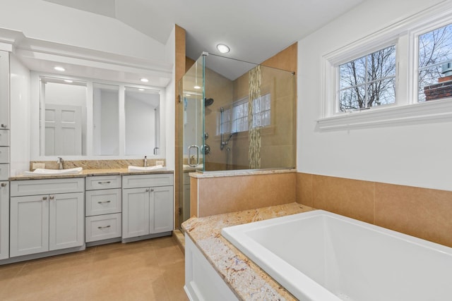 bathroom featuring vaulted ceiling, tile patterned flooring, separate shower and tub, and vanity