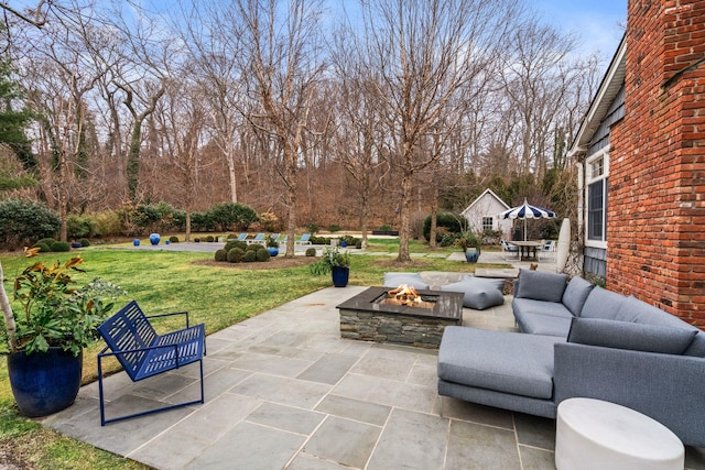 view of patio with an outdoor living space with a fire pit