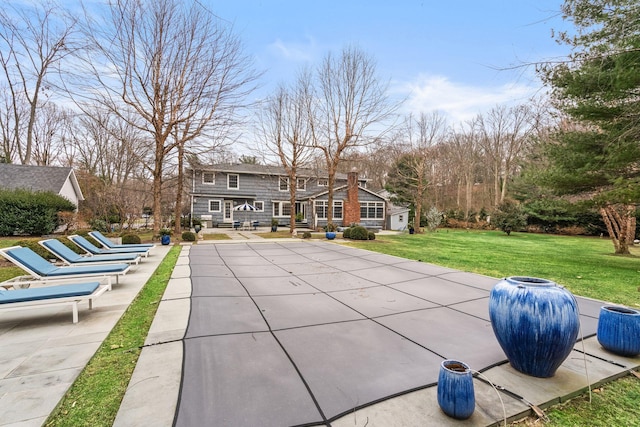 back of property featuring a lawn and a patio