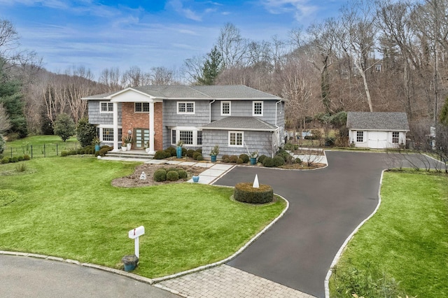 view of front of house with an outdoor structure and a front yard