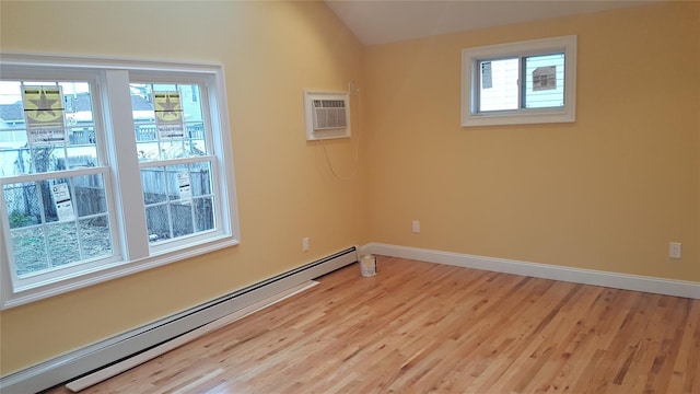 spare room with vaulted ceiling, an AC wall unit, a baseboard heating unit, and light hardwood / wood-style floors