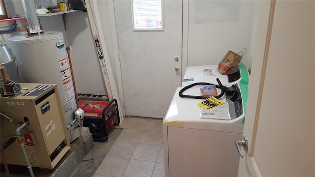 clothes washing area featuring washing machine and dryer, light tile patterned floors, and gas water heater