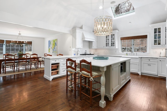 kitchen featuring a kitchen island, white cabinetry, and a notable chandelier