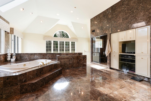 bathroom with a relaxing tiled tub and lofted ceiling