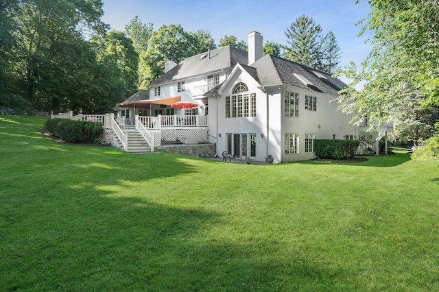 rear view of house with a wooden deck and a yard