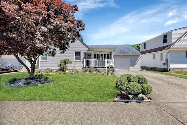 view of front of house with covered porch, a front yard, and a garage