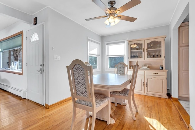 dining area featuring baseboard heating, light wood-type flooring, and ceiling fan